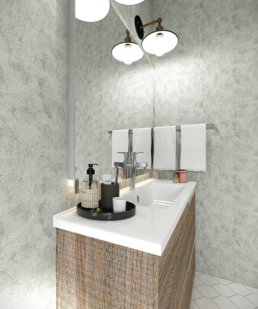 A modern bathroom showcasing a textured wood vanity with a sleek white countertop, minimalist chrome faucet, and soft patterned wallpaper. Above the vanity, retro-style brass and glass light fixtures add character, while neatly folded white towels and a black tray with toiletries enhance functionality and elegance.

