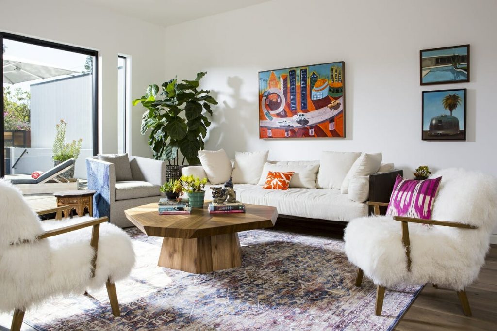 A stylish coffee table featuring neatly arranged books, a candle, and a decorative vase, showcasing effortless chic living room decor.