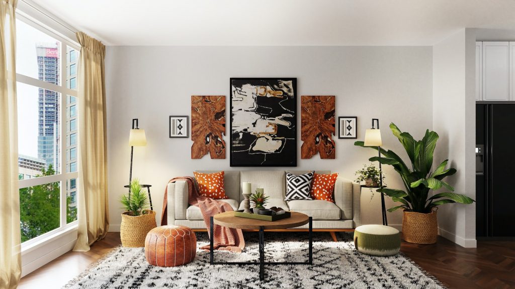 A cozy living room with a neutral sofa, patterned cushions, a soft woven throw, bold wall art, textured rugs, and natural accents like plants and baskets for depth and warmth.