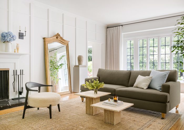 A chic coffee table styled with a color-coordinated tray, books, fresh flowers, and decorative accents, reflecting a cohesive and natural design