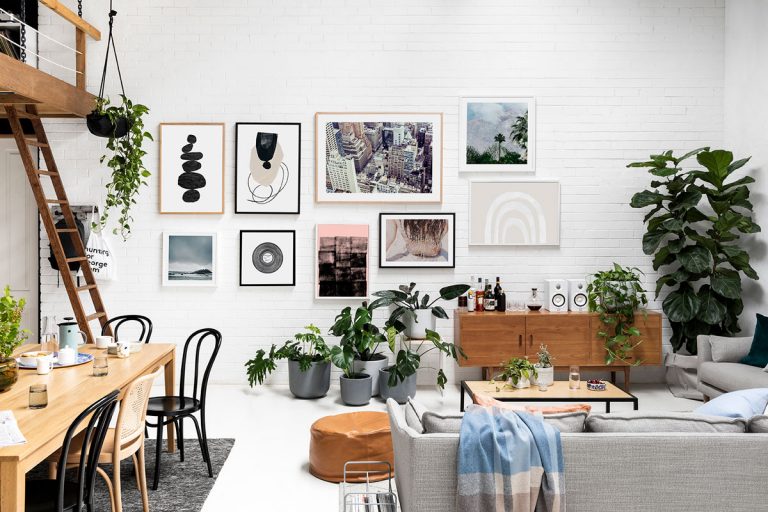 A modern and inviting living room featuring neutral-toned furniture, elegant wall moldings, a glass coffee table, and carefully curated decor pieces, emphasizing cohesion and functionality in design.
