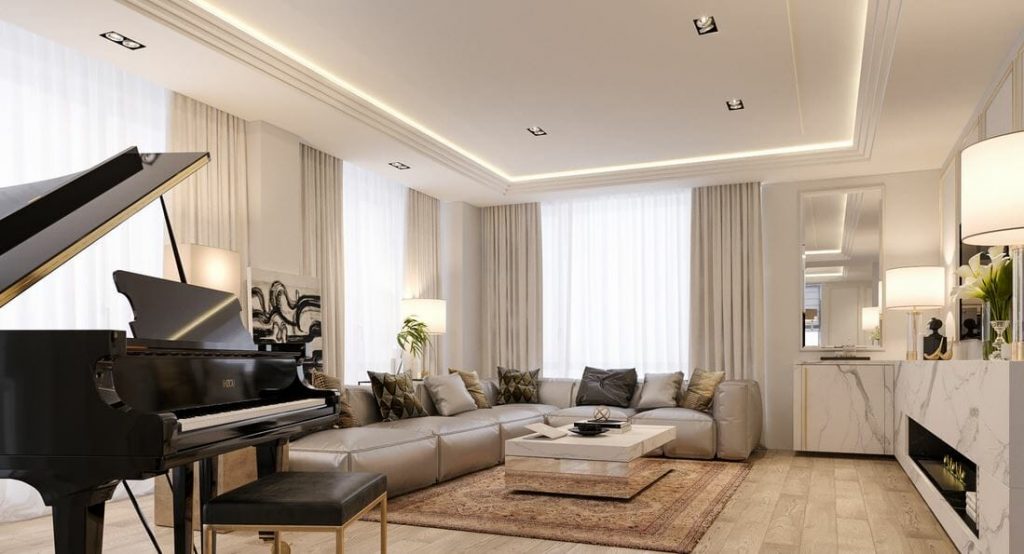 A luxurious living room featuring a grand piano, a large sectional sofa with neutral cushions, and ambient lighting integrated into the ceiling design. The room is accented by a modern coffee table, a warm area rug, and elegant marble cabinetry.