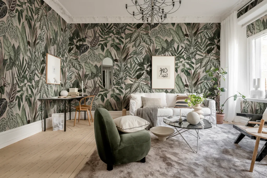  A cozy dining room featuring a sleek glass table, woven chairs, a textured rug, and a tropical green mural wallpaper, combining varied textures for a dynamic and inviting eclectic design.
