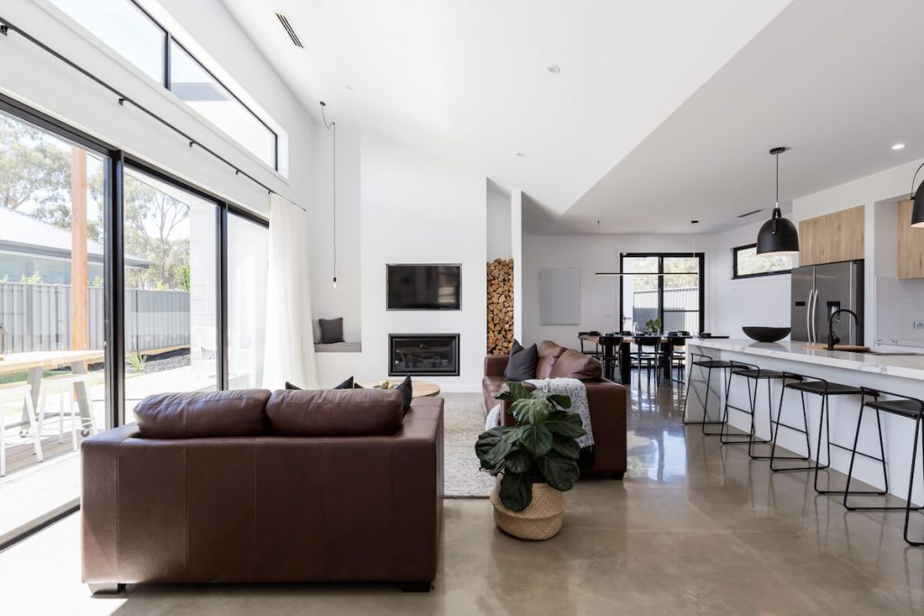 A contemporary living room with a sleek sofa, neutral tones, minimalist decor, and a modern coffee table placed on a soft area rug